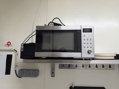 a microwave that is sitting on a shelf in a room