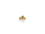 gros plan d'une bague en or avec une pierre bleue