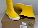 une paire de bottes de pluie jaunes posée sur une boîte en carton