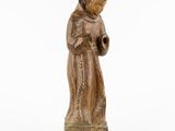 a wooden statue of a monk with a pipe in his hand