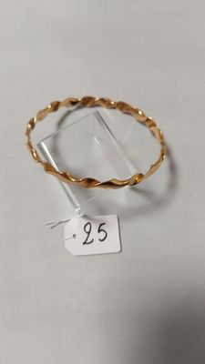 gros plan d'une bague en or sur une surface blanche