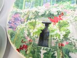 a plate with a picture of a garden on it