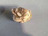 a small ivory figurine sitting on top of a table