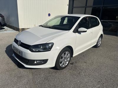 La Volkswagen Polo blanche est garée devant un immeuble.