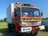 un camion garé dans un champ à côté d'une voiture