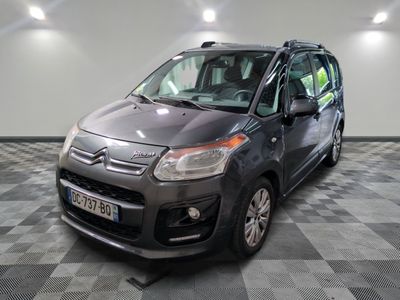 une photo d'une petite camionnette grise garée dans un garage
