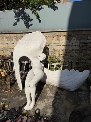a statue of a woman holding a bird next to a boat