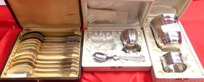 des couverts dans un coffret en argent posé sur une nappe rouge