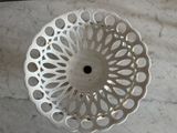 a white bowl with holes in it on a marble table