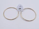 a pair of gold hoop earrings on a white background
