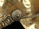 a close up of a gold helmet on a black background