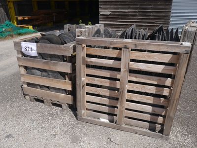 two wooden pallets with a lot of black tires in them