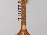 un gros plan d'un instrument de musique posé sur un support, sur fond gris