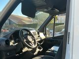 l'intérieur d'une camionnette blanche dont la porte est ouverte et le siège conducteur rabattu