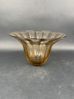 yellow glass bowl on a gray surface with a silver background