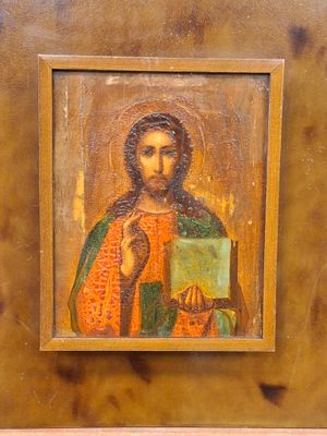 une image représentant un tableau de Jésus tenant une bougie, dans un cadre en bois