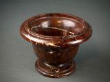 a brown marble bowl on a black surface