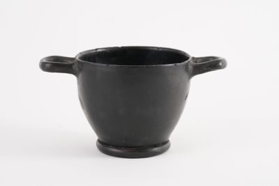 a black cup that is sitting on a white surface