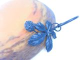 a blue vase with a flower on it on a white surface