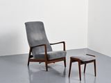 un fauteuil et un pouf dans une pièce aux murs blancs