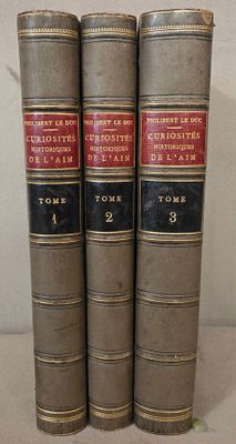 trois livres sont empilés sur une table
