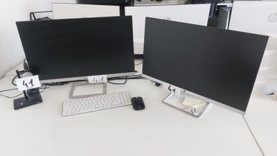 deux écrans d'ordinateur posés sur un bureau avec un clavier et une souris