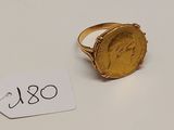 Gros plan sur une bague ornée d'une pièce d'or