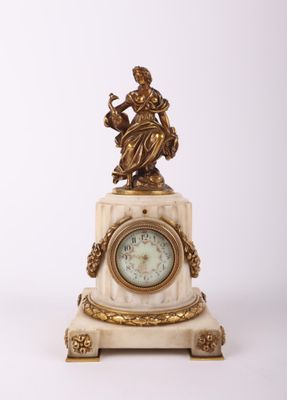 une petite horloge surmontée d'une statue