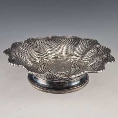 une assiette en argent antique avec un motif de fleur