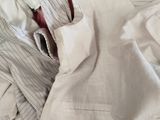 a pile of clothes that is sitting on a bed