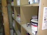 several buckets of paint sitting on a shelf in a room