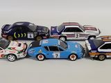 several toy cars are lined up in a row on a white surface
