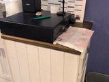 a picture of a counter with a phone and a trash can