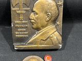 une photo d'une plaque en bronze sur laquelle figure le portrait d'un homme