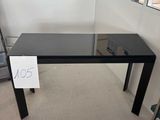 une table en verre sur laquelle est posé un panneau, dans une pièce