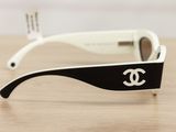 chanel sunglasses on a wooden table with a black and white frame
