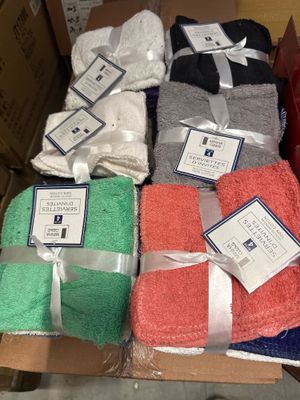 Des cartons contenant des serviettes assorties sont empilés les uns sur les autres
