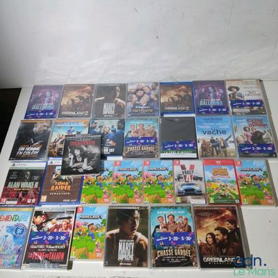 De nombreux DVD sont empilés sur une table devant un mur blanc.