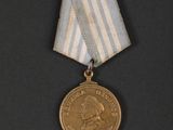 a gold medal with a blue and white ribbon on a black background