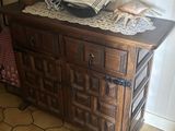 une commode sur laquelle est posé un vase, dans une pièce