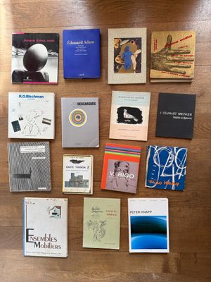 several books are arranged on a wooden table with a wooden floor