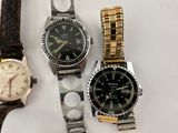three different watches sitting next to each other on a table