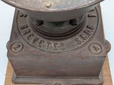 an old cast iron grinder on a wooden stand