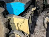 a tractor with a blue box on the back of it