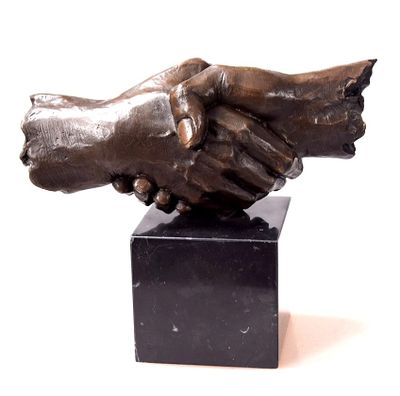 statue of two hands shaking each other on a black marble base