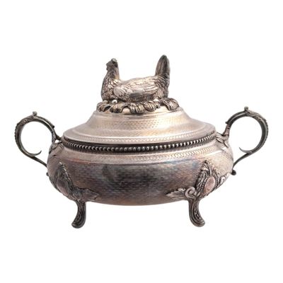 an antique silver plate with two handles and a dog head on the top