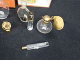 a bottle of perfume next to a lighter and a glass bottle of perfume