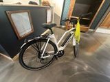 un vélo blanc avec un sac jaune à l'arrière