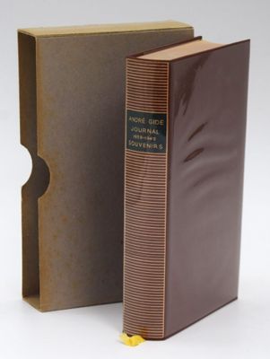 a brown book sitting next to a brown box on top of a white surface