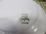 a white plate with a green design on it on a table